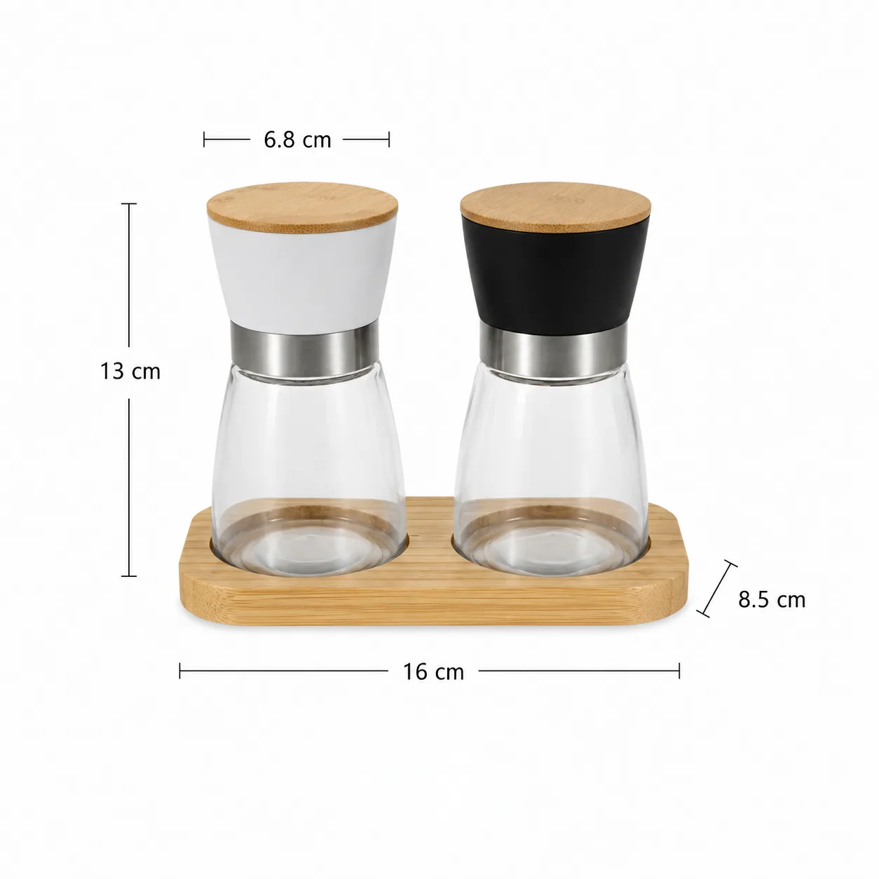 Two glass spice grinders with bamboo lids on bamboo tray